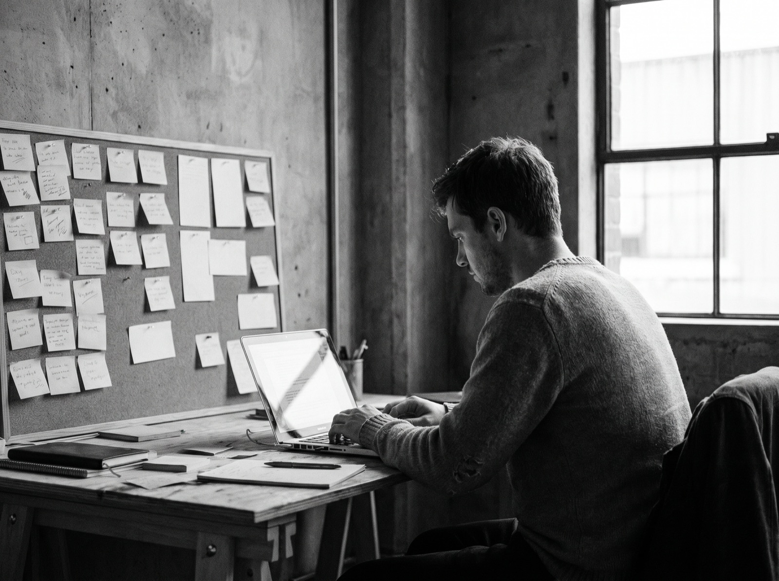 A copywriter working on messaging with notes on a wall